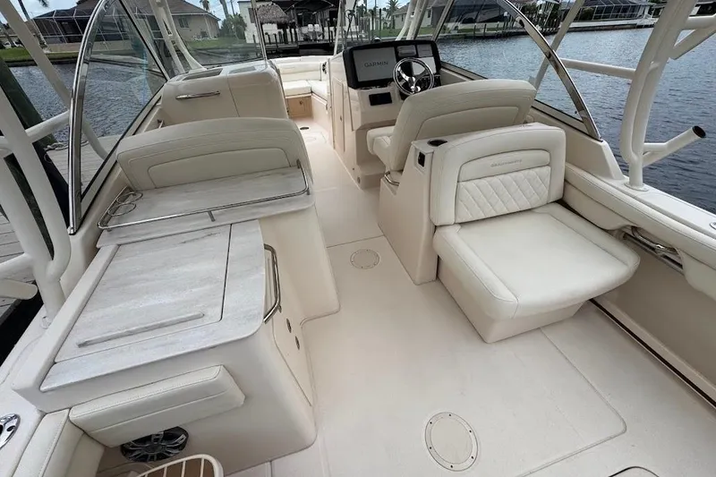 Slide: The Image of 2020 Grady-White Freedom 285 boat interior with luxurious seating and helm, dockside view. - 50