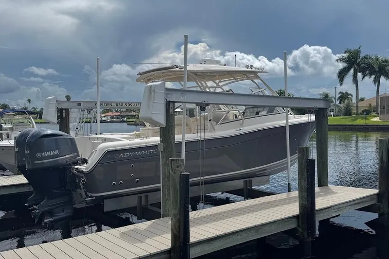 Slide: The Image of 2020 Grady-White Freedom 285 boat docked with Yamaha engine, under cloudy sky. - 56