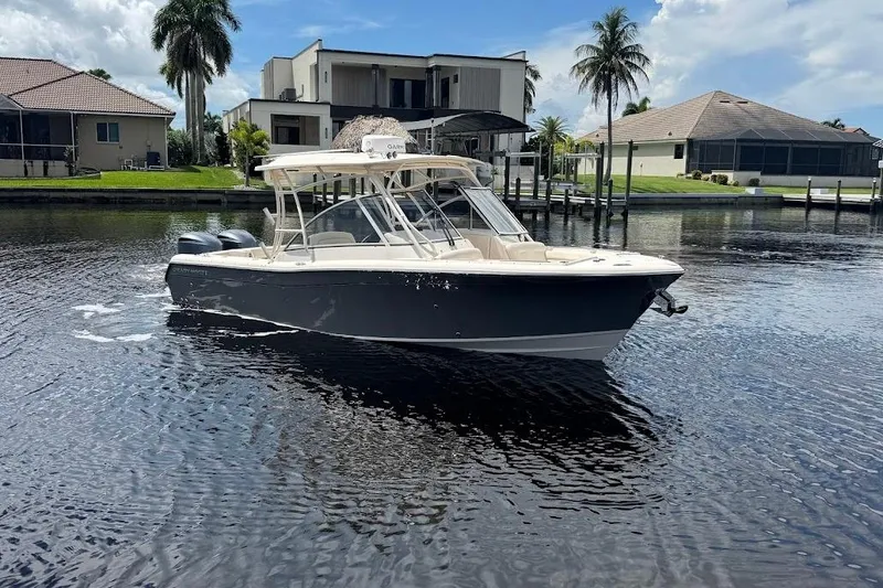Slide: The Image of 2020 Grady-White Freedom 285 boat on calm water near waterfront homes. - 8
