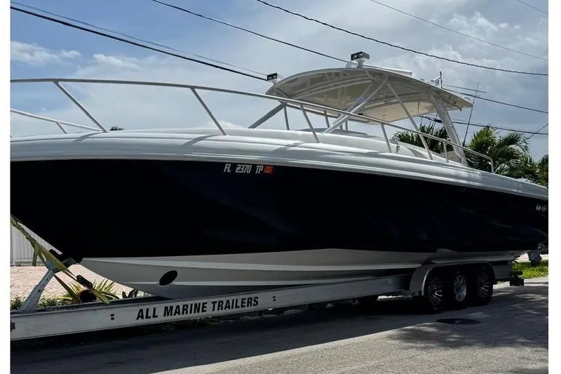 Slide: The Image of 2006 Intrepid 377 Walkaround boat on trailer, parked on roadside under clear sky. - 1