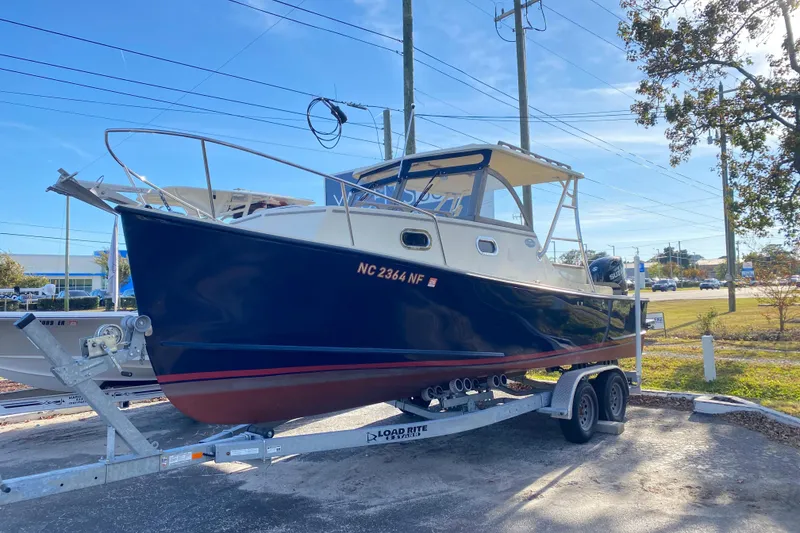 The Image of 2023 Seaway 24 Seafarer boat on calm water near a wooden dock. - 0