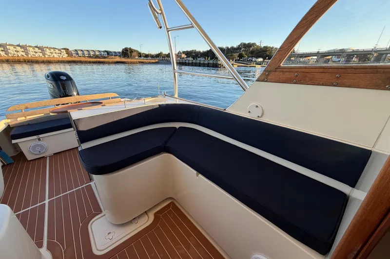 Slide: The Image of 2023 Seaway 24 Seafarer boat interior with cushioned seating and scenic waterfront view. - 13