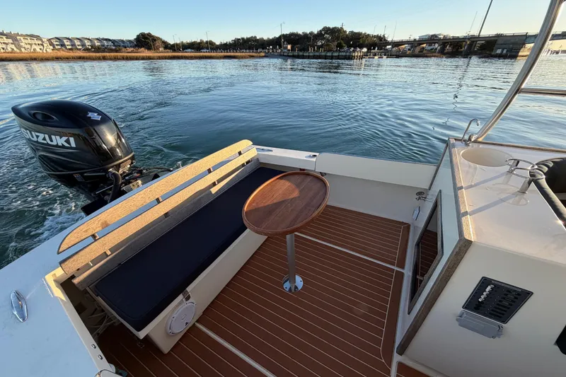 Slide: The Image of 2023 Seaway 24 Seafarer boat interior with Suzuki outboard motor, wooden deck, and seating area. - 15