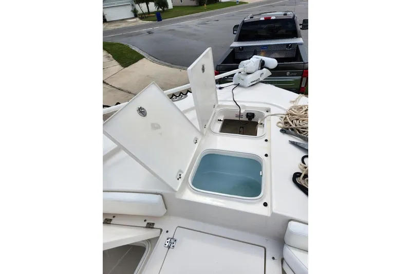 Slide: The Image of 2020 Robalo 246 Cayman boat deck with open storage compartments and fishing gear. - 17