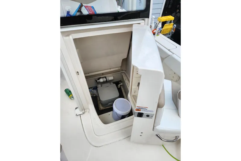 Slide: The Image of 2020 Robalo 246 Cayman boat storage compartment with open hatch and cleaning supplies. - 20