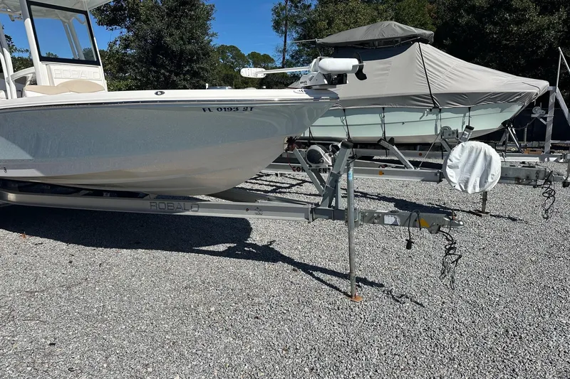 Slide: The Image of 2020 Robalo 246 Cayman boat on trailer, parked on gravel lot, sunny day. - 3