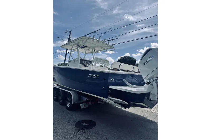 Slide: The Image of 2005 Jupiter 31 boat on trailer with Yamaha outboard, under a clear blue sky. - 11