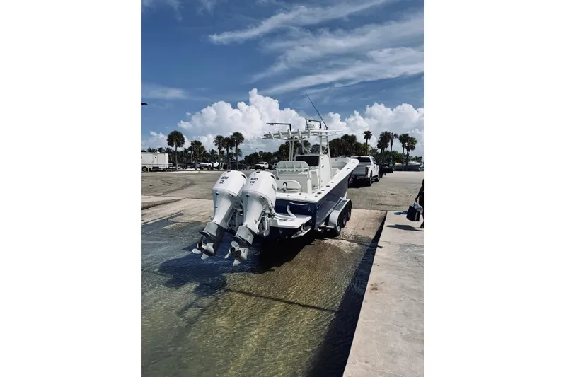Slide: The Image of 2005 Jupiter 31 boat with dual engines at a boat ramp under a blue sky. - 17