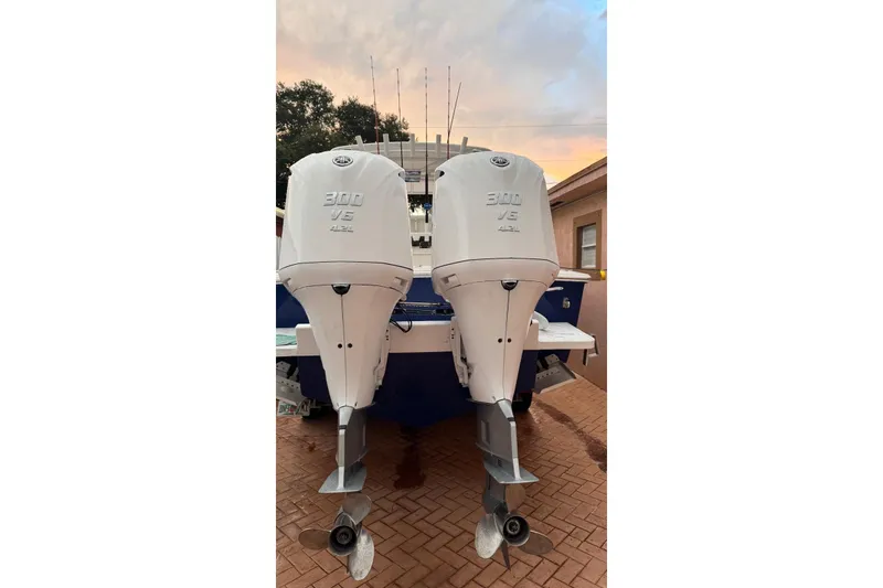 Slide: The Image of Twin 300 V6 outboard engines on a 2005 Jupiter 31 boat at sunset. - 4