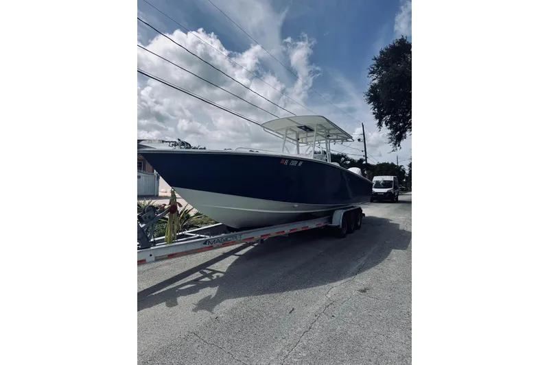 Slide: The Image of 2005 Jupiter 31 boat on trailer under cloudy sky. - 9