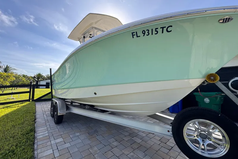 Slide: The Image of 2022 Robalo R230 Center Console boat on trailer, parked on paved driveway. - 15