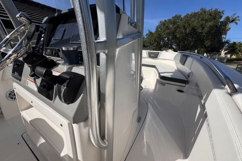 Slide: The Image of 2022 Robalo R230 Center Console boat interior with steering wheel and seating area. - 21