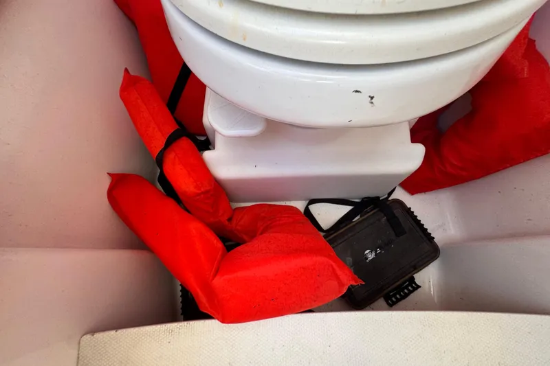 Slide: The Image of Red life jackets stored in a 2022 Robalo R230 Center Console boat compartment. - 30