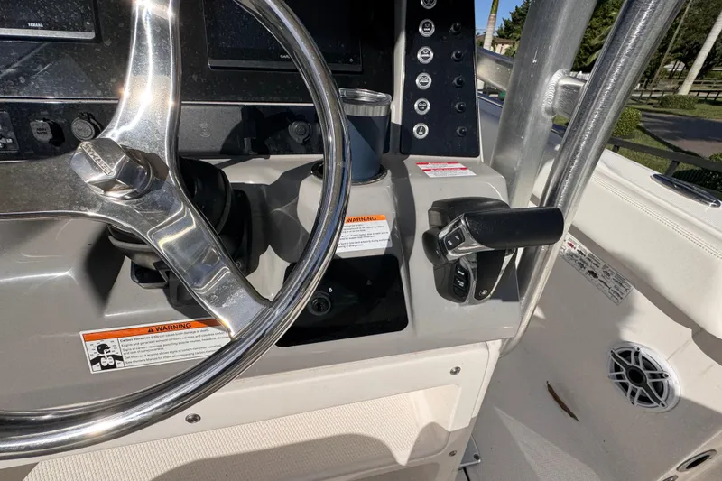 Slide: The Image of 2022 Robalo R230 Center Console boat dashboard with steering wheel and controls. - 36