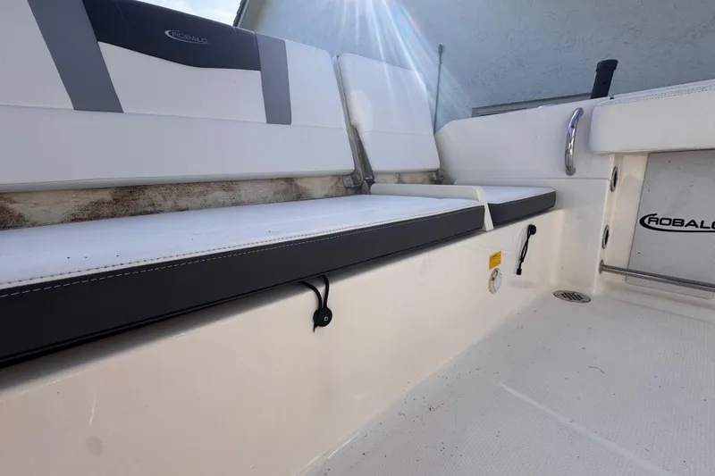 Slide: The Image of 2022 Robalo R230 Center Console boat interior with cushioned seating and branded details. - 51