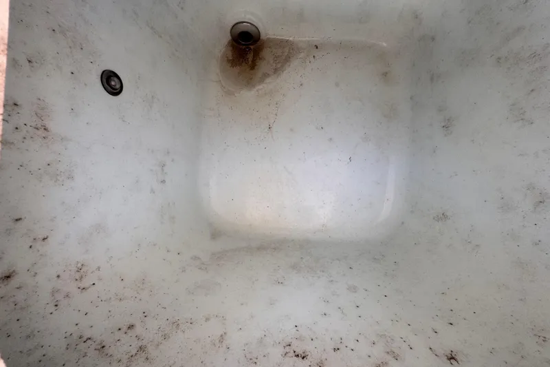 Slide: The Image of Dirty interior of a 2022 Robalo R230 Center Console boat compartment. - 54