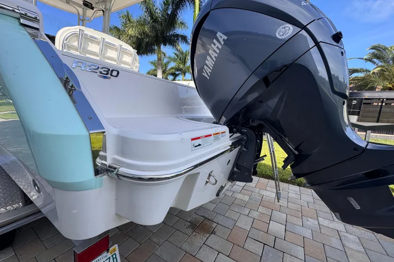 Slide: The Image of 2022 Robalo R230 Center Console boat with Yamaha outboard motor, parked on a paved surface. - 6