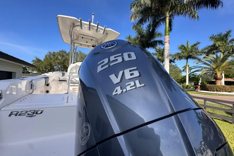 Slide: The Image of 2022 Robalo R230 Center Console boat with Yamaha 250 V6 engine, palm trees in background. - 9