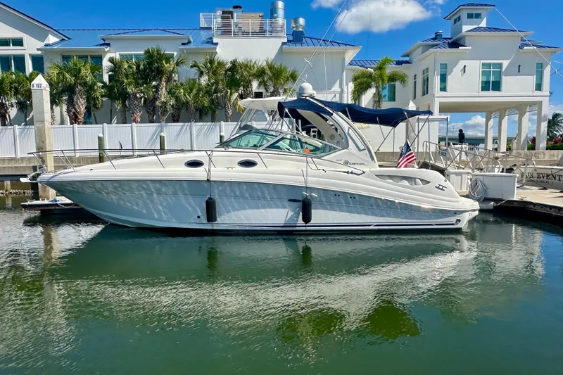 The Image of 2008 Sea Ray 340 Sundancer yacht docked near luxury waterfront homes. - 0