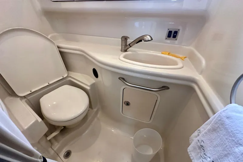 Slide: The Image of 2008 Sea Ray 340 Sundancer bathroom with toilet, sink, and storage cabinet. - 13