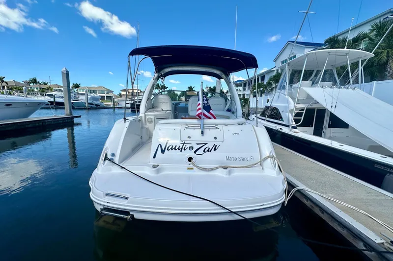 Slide: The Image of 2008 Sea Ray 340 Sundancer docked at marina, featuring American flag. - 2