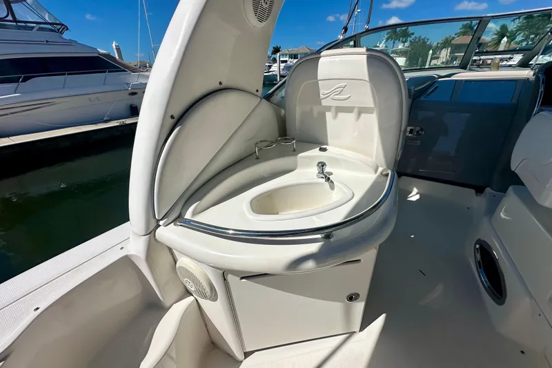 Slide: The Image of 2008 Sea Ray 340 Sundancer boat sink area with sleek design and marina background. - 6