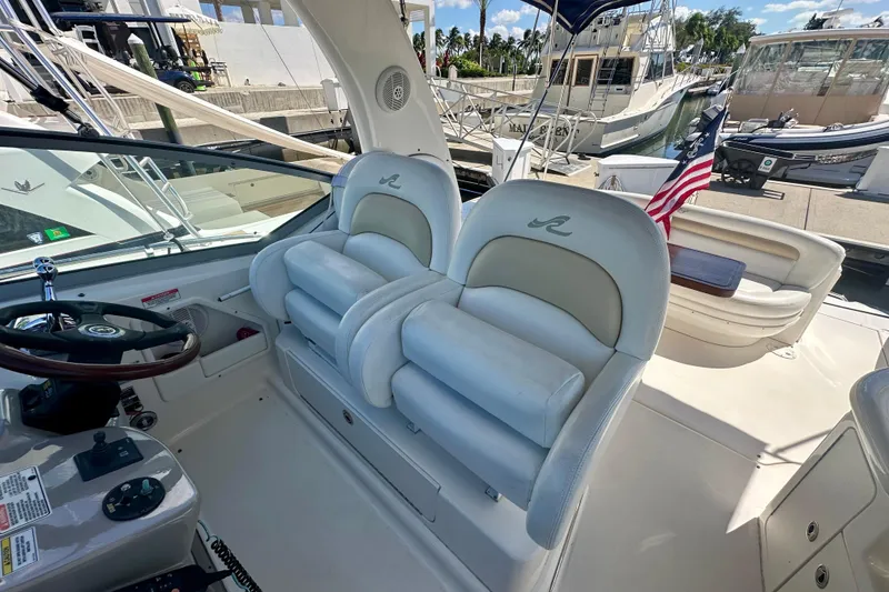 Slide: The Image of 2008 Sea Ray 340 Sundancer cockpit with plush seating and helm, docked at marina. - 9