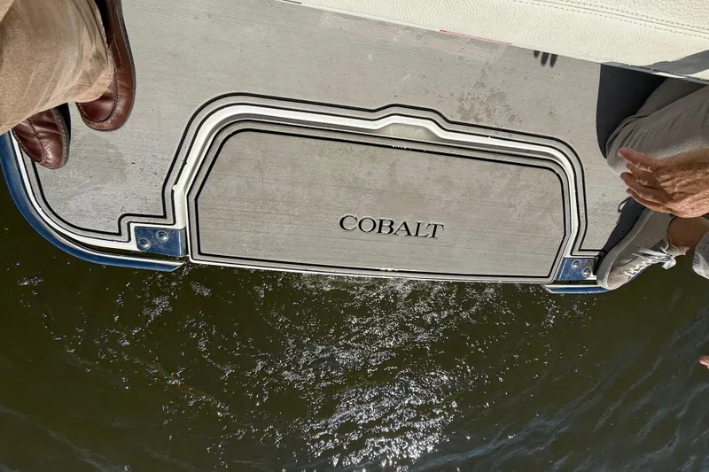 Slide: The Image of 2018 Cobalt R3 Surf boat platform above water, featuring logo and passengers' feet. - 10