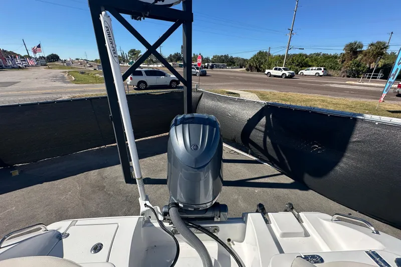 Slide: The Image of 2024 Sea Hunt Ultra 219 boat with outboard motor, parked outdoors. - 10