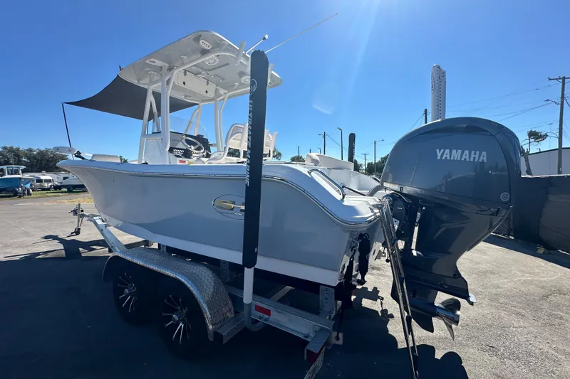 Slide: The Image of 2024 Sea Hunt Ultra 219 boat with Yamaha engine on trailer, sunny day. - 101