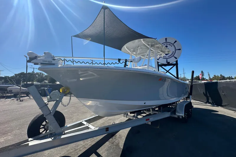 Slide: The Image of 2024 Sea Hunt Ultra 219 boat on trailer under sunshade, parked outdoors. - 103