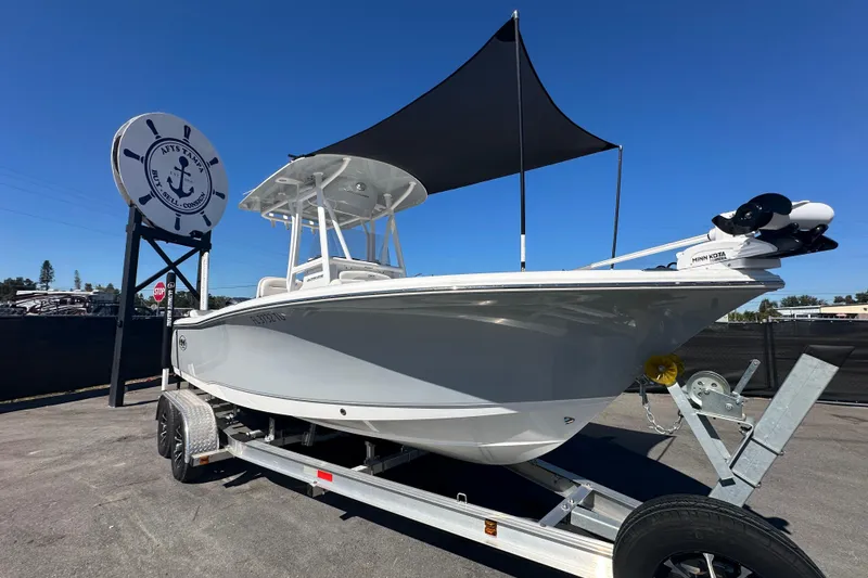 Slide: The Image of 2024 Sea Hunt Ultra 219 boat on trailer, displayed outdoors under clear blue sky. - 106