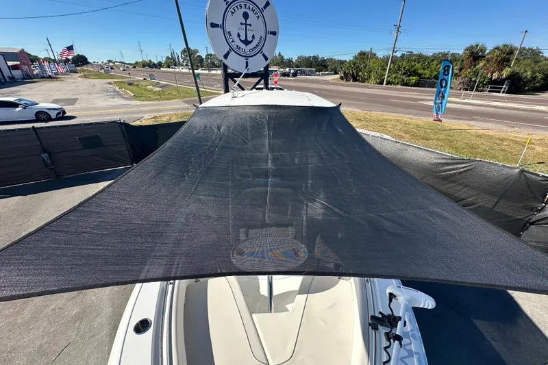 Slide: The Image of 2024 Sea Hunt Ultra 219 boat with sunshade, parked near a road. - 109