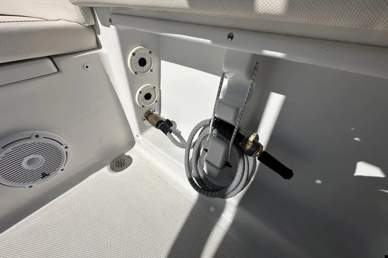 Slide: The Image of 2024 Sea Hunt Ultra 219 boat interior with hose and speaker details. - 11