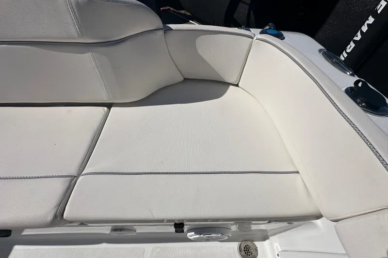 Slide: The Image of 2024 Sea Hunt Ultra 219 boat seating with white upholstery and cup holders. - 12