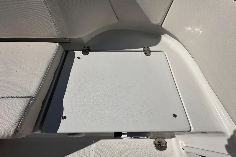 Slide: The Image of 2024 Sea Hunt Ultra 219 boat interior with storage compartment and seating. - 16