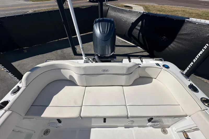 Slide: The Image of 2024 Sea Hunt Ultra 219 boat interior with cushioned seating and outboard motor. - 19