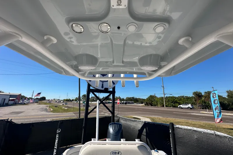 Slide: The Image of 2024 Sea Hunt Ultra 219 boat interior view with overhead console and outdoor setting. - 31