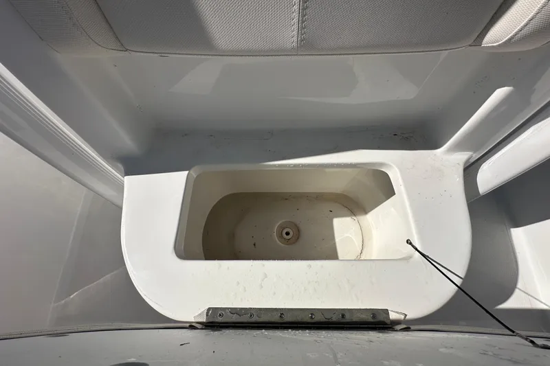 Slide: The Image of 2024 Sea Hunt Ultra 219 boat interior storage compartment, white and spacious design. - 32
