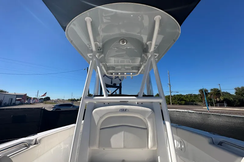 Slide: The Image of 2024 Sea Hunt Ultra 219 boat with T-top, viewed from the deck under clear blue sky. - 39