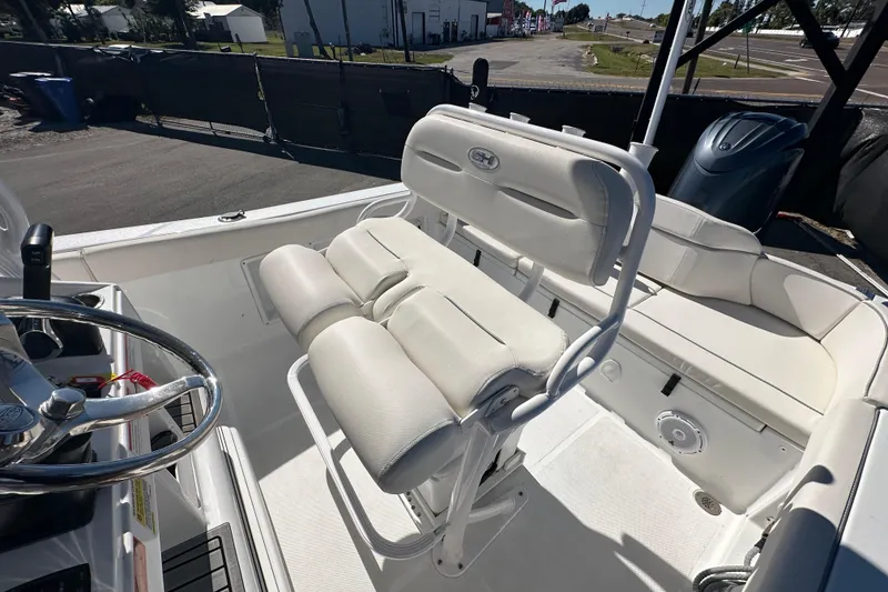 Slide: The Image of 2024 Sea Hunt Ultra 219 boat interior with white seating and steering wheel. - 44