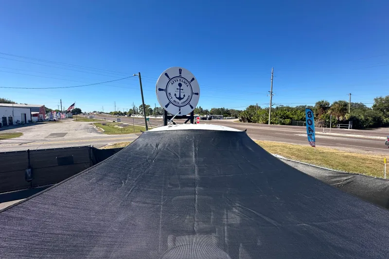 Slide: The Image of 2024 Sea Hunt Ultra 219 boat displayed at a dealership under clear blue skies. - 45