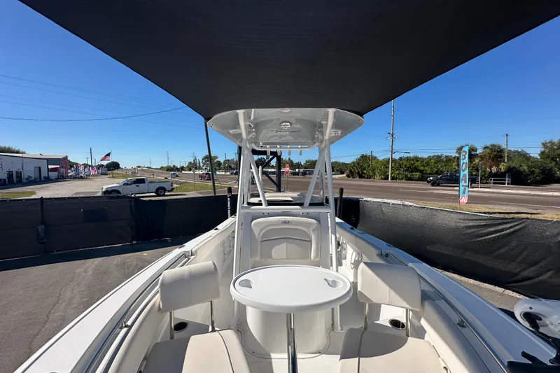 Slide: The Image of 2024 Sea Hunt Ultra 219 boat interior with seating and table under canopy. - 49