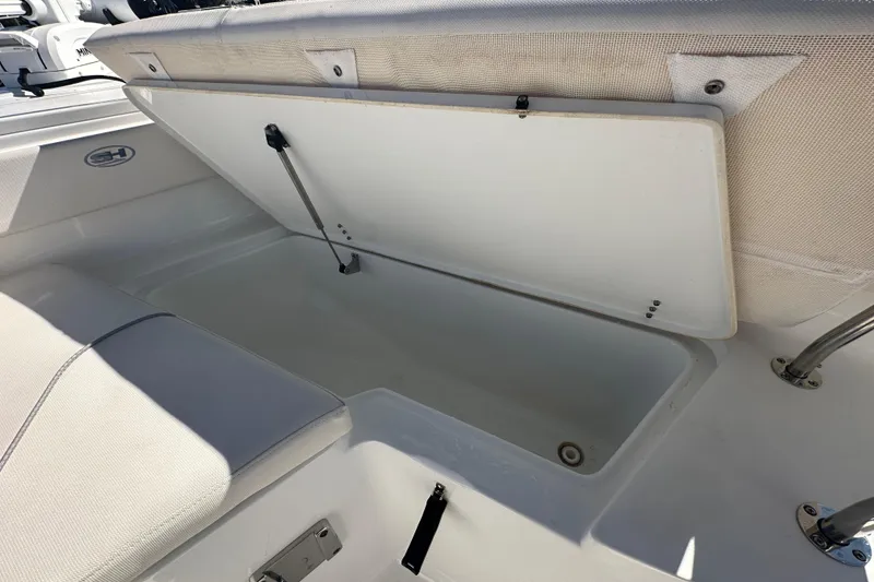 Slide: The Image of 2024 Sea Hunt Ultra 219 boat storage compartment with open lid. - 52