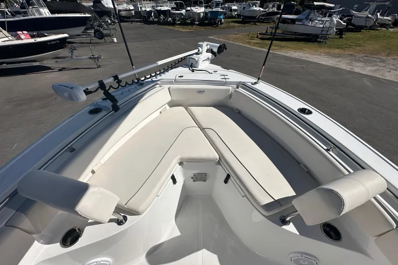 Slide: The Image of 2024 Sea Hunt Ultra 219 boat interior with cushioned seating and fishing rod holders. - 56