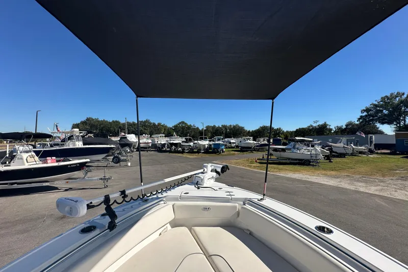 Slide: The Image of 2024 Sea Hunt Ultra 219 boat with canopy in a marina setting. - 58