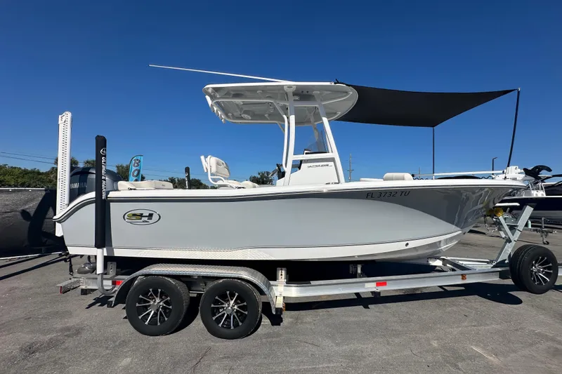 Slide: The Image of 2024 Sea Hunt Ultra 219 boat on trailer, side view, clear blue sky. - 6