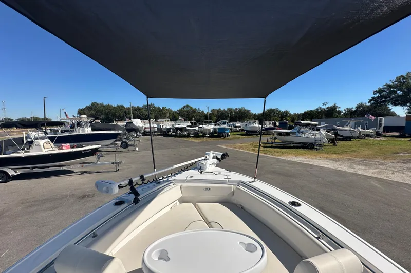 Slide: The Image of 2024 Sea Hunt Ultra 219 boat with canopy, parked in a marina. - 61