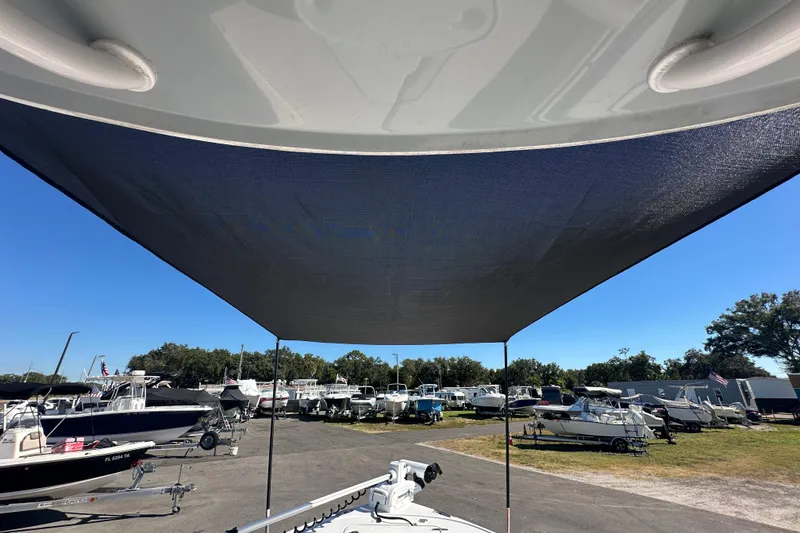 Slide: The Image of 2024 Sea Hunt Ultra 219 boat with sunshade in a marina setting. - 62