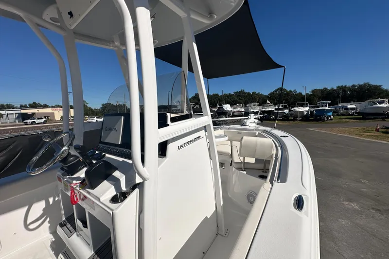 Slide: The Image of 2024 Sea Hunt Ultra 219 boat with Garmin navigation, docked under clear blue sky. - 64